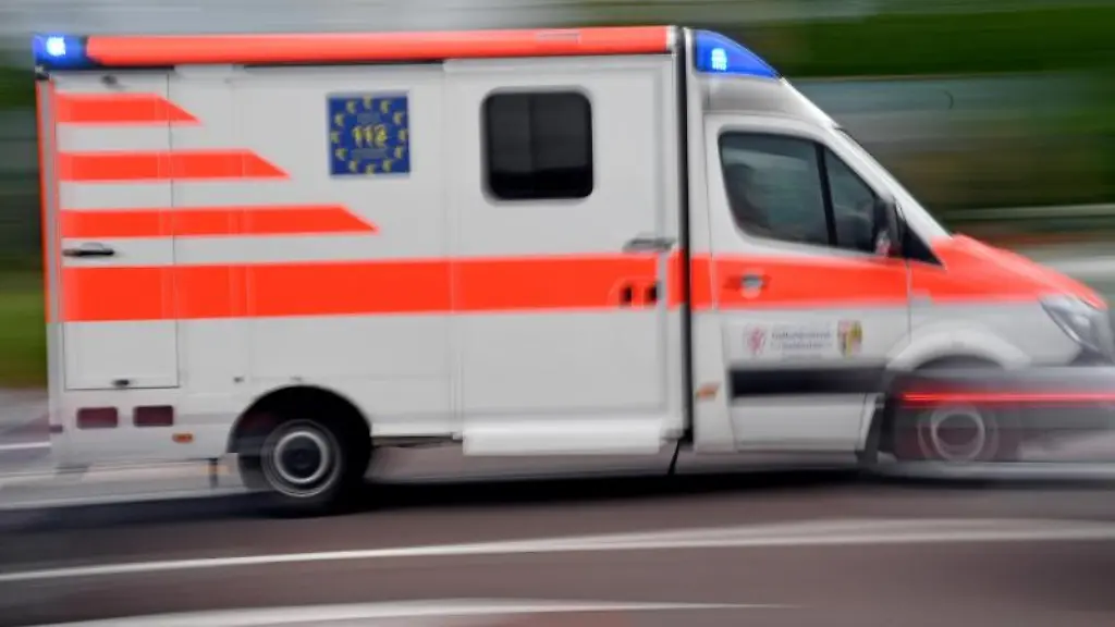 Ein-Krankenwagen-faehrt-mit-Blaulicht-auf-einer-Strasse