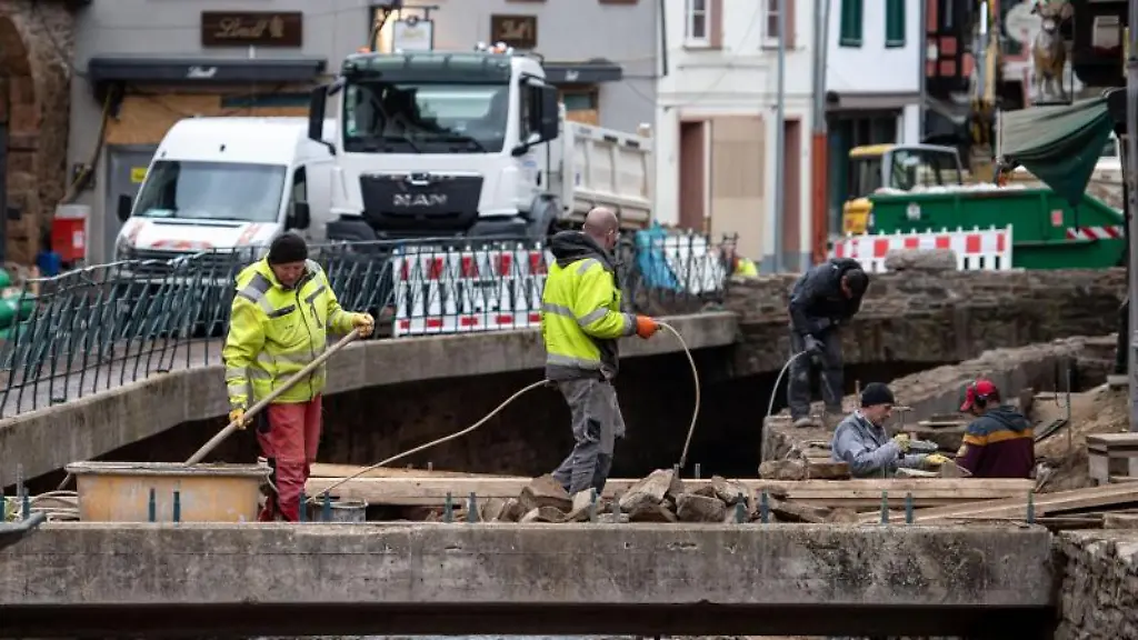Maenner-arbeiten-an-einer-Bruecke-und-am-Ufer-der-Erft
