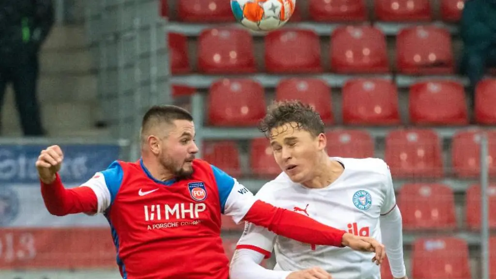 Heidenheims-Marnon-Busch-l-und-Kiels-Benedikt-Pichler-kaempfen-um-den-Ball