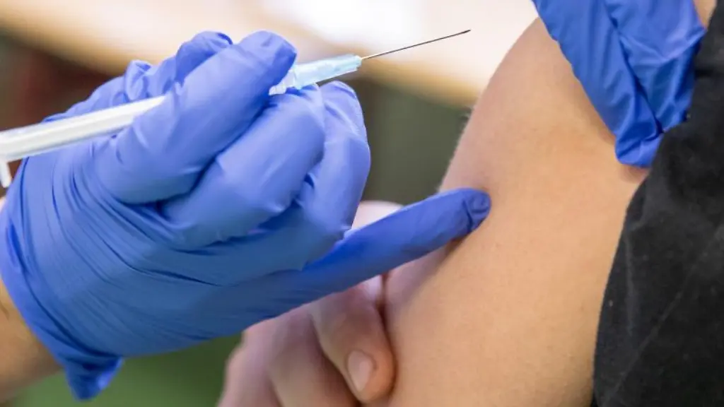 Ein-medizinischer-Mitarbeiter-setzt-am-Arm-eines-Jugendlichen-zur-Corona-Impfung-an