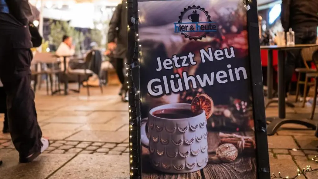 Jetzt-Gluehwein-steht-auf-einem-Schild-unweit-vom-Weihnachtsmarkt-auf-dem-Rathausplatz