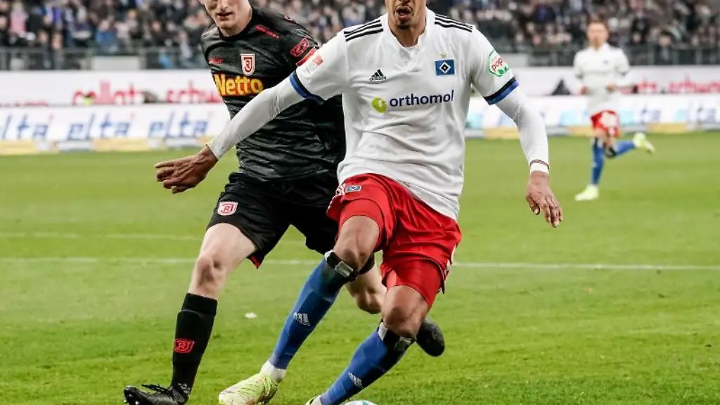 Regensburgs-Scott-Kennedy-l-und-Hamburgs-Robert-Glatzel-kaempfen-um-den-Ball