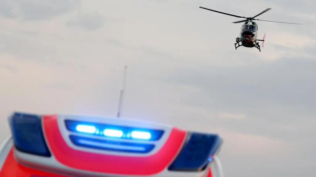 Ein-Hubschrauber-fliegt-ueber-einem-Rettungswagen-zu-einem-Unfallort