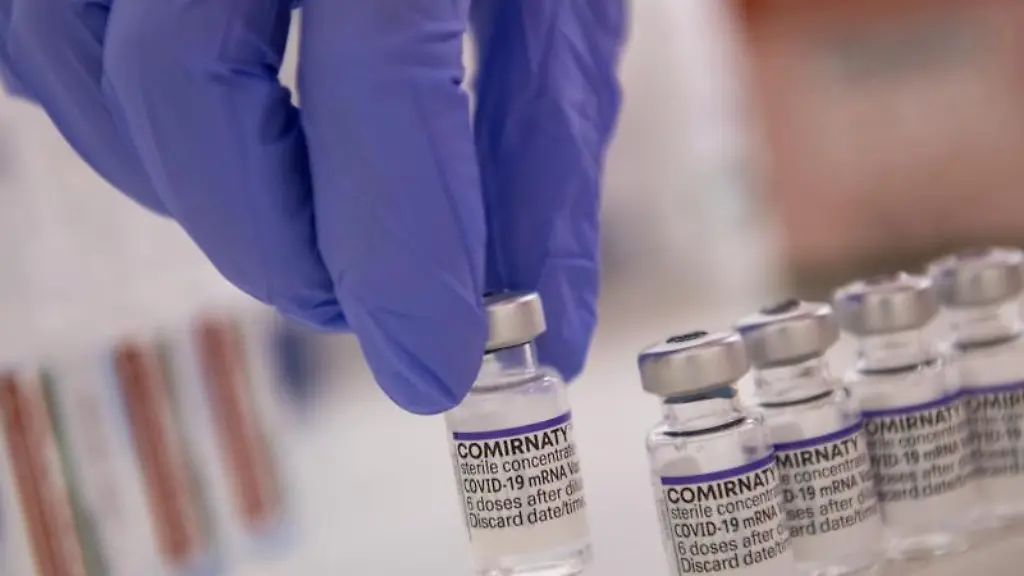 Eine-Arzthelferin-haelt-eine-Ampulle-mit-dem-Corona-Impfstoff-von-Biontech-Pfizer-in-der-Hand