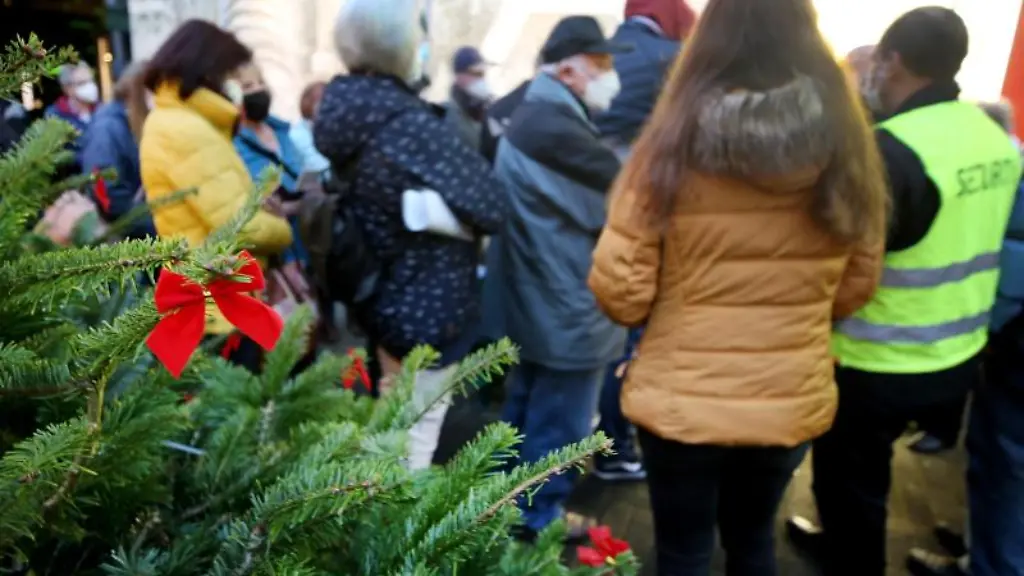 Buerger-warten-vor-der-Corona-Impfstation-direkt-am-Weihnachtsmarkt