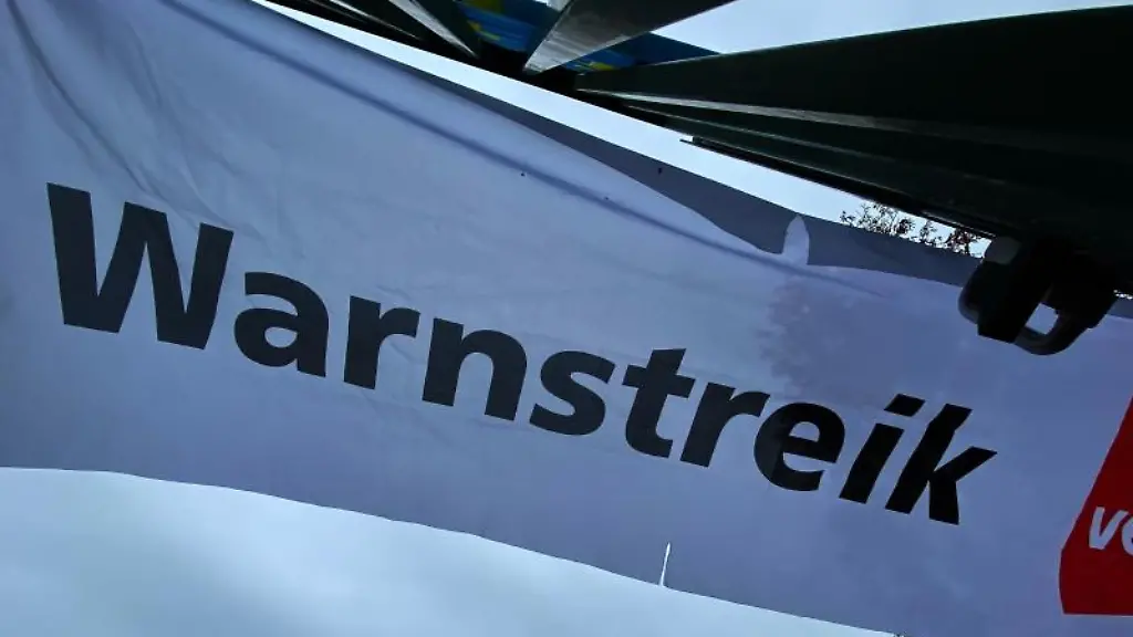 Ein-Transparent-wird-bei-einem-Warnstreik-hochgehalten