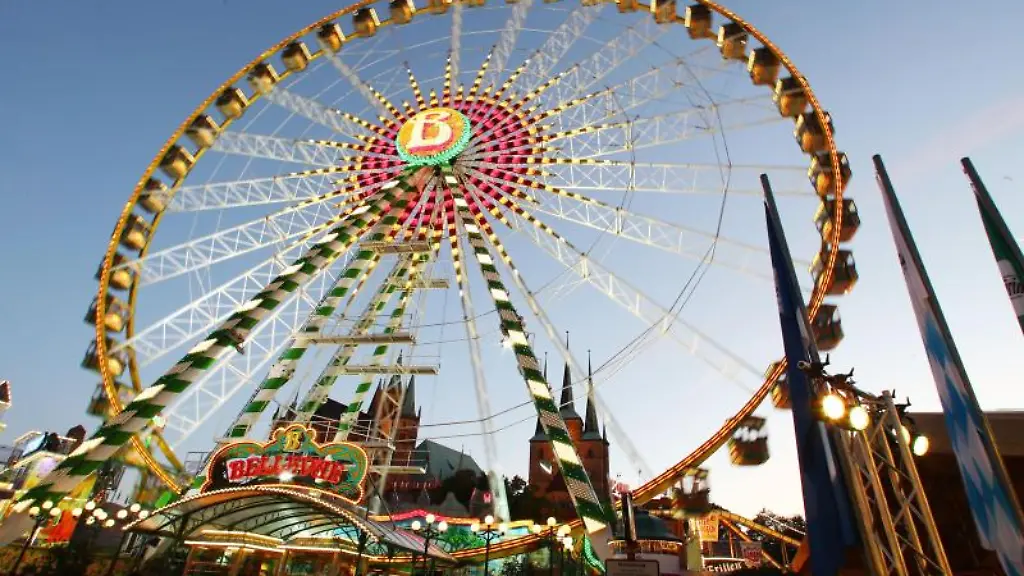 Bunt-beleuchtete-Fahrgeschaefte-sind-vor-der-Kulisse-des-Erfurter-Doms-zu-sehen