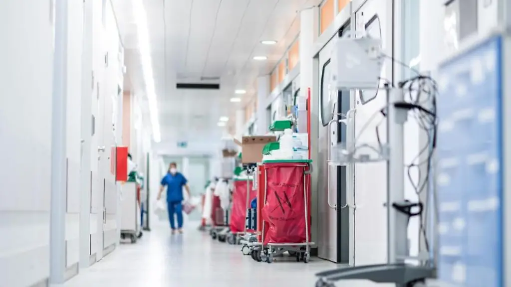 Eine-Pflegekraft-geht-auf-einer-Intensivstation-ueber-den-Flur