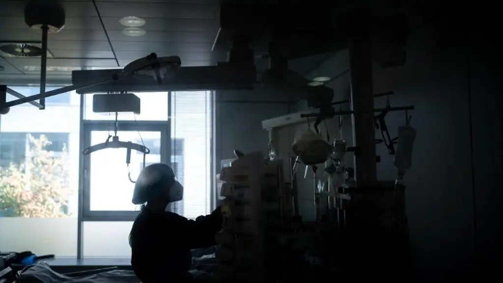 Eine-Mitarbeiterin-der-Pflege-steht-in-einem-Zimmer-einer-Corona-Intensivstation