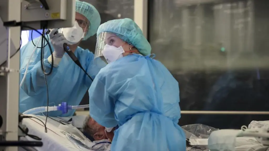 Ein-Facharzt-und-eine-Intensivpflegerin-r-intubieren-einen-Covid-19-Patienten-auf-der-Intensivstation