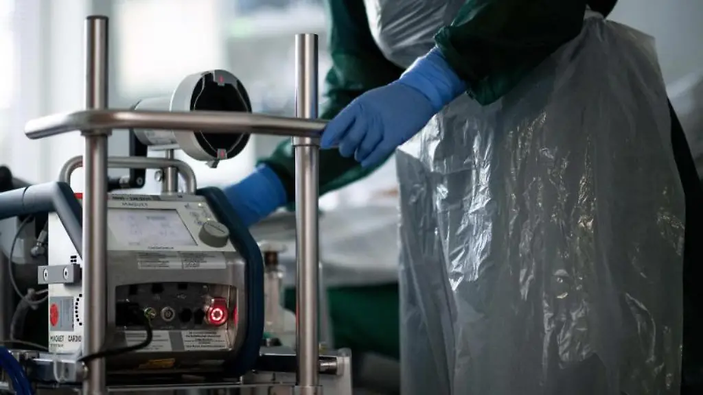 Eine-Mitarbeiterin-der-Pflege-steht-in-einem-Zimmer-einer-Corona-Intensivstation