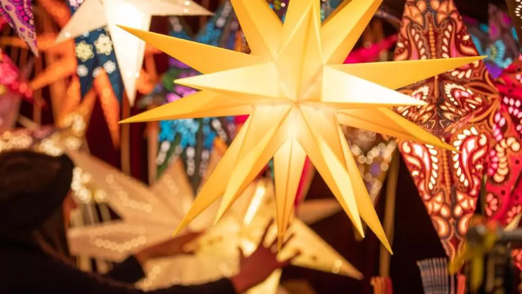 Bunte-Weihnachtssterne-werden-an-einem-Stand-auf-dem-Weihnachtsmarkt-angeboten