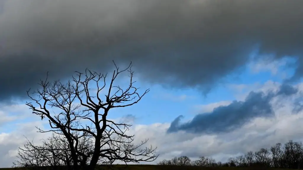 Dunkle-Wolken-ziehen-ueber-eine-Landschaft