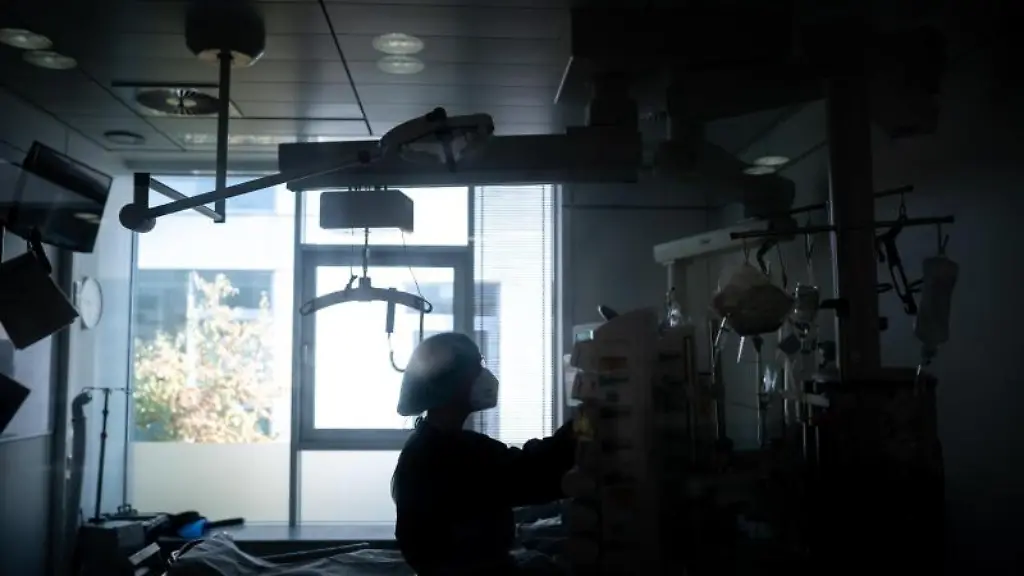 Eine-Mitarbeiterin-der-Pflege-steht-in-einem-Zimmer-einer-Corona-Intensivstation