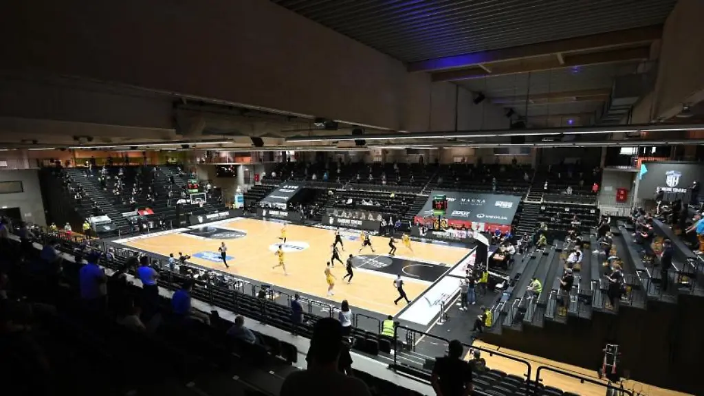 Zuschauer-sitzen-mit-Abstand-auf-der-Tribuene-und-verfolgen-ein-Spiel