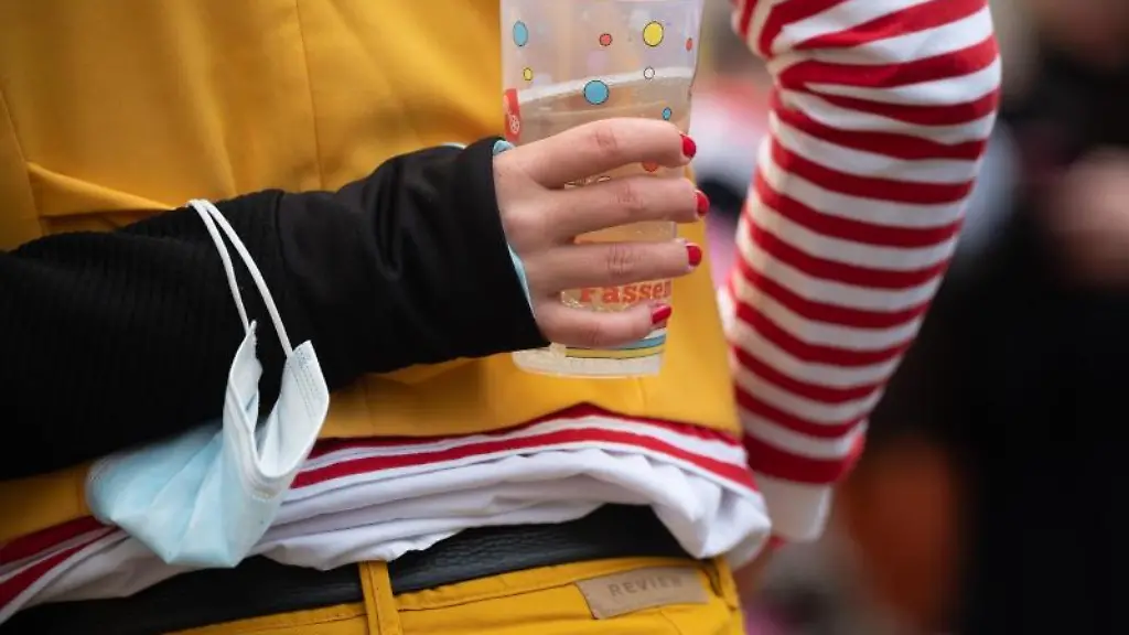 Eine-Frau-traegt-auf-dem-Schillerplatz-einen-medizinischen-Mundschutz-am-Arm