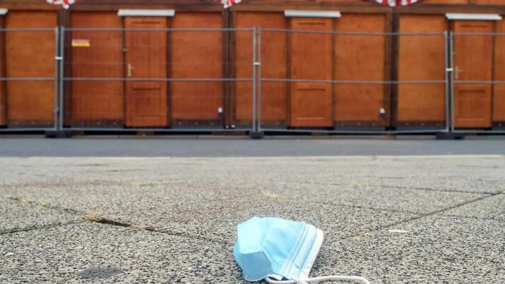 Ein-Mund-Nasen-Schutz-liegt-in-Magdeburg-vor-geschlossenen-Weihnachtsmarkt-Buden