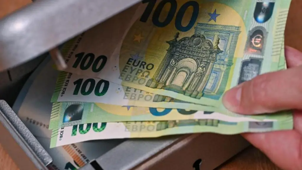 Eine-Frau-holt-Eurobanknoten-aus-einer-kleinen-Geldkassette