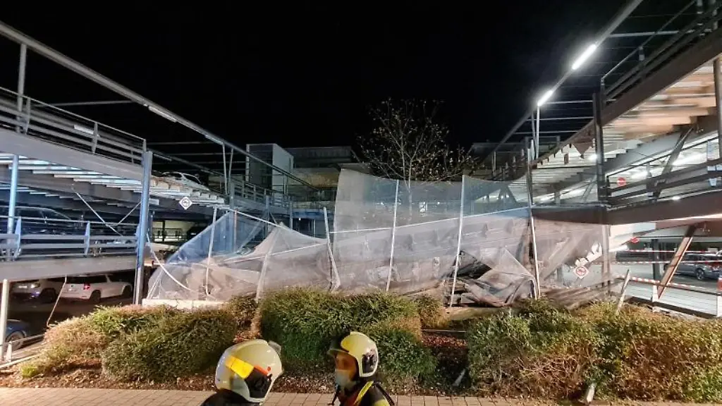 Einsatzkraefte-stehen-vor-den-eingestuerzten-Teilen-eines-Parkhauses-am-Helios-Klinikum-in-Erfurt
