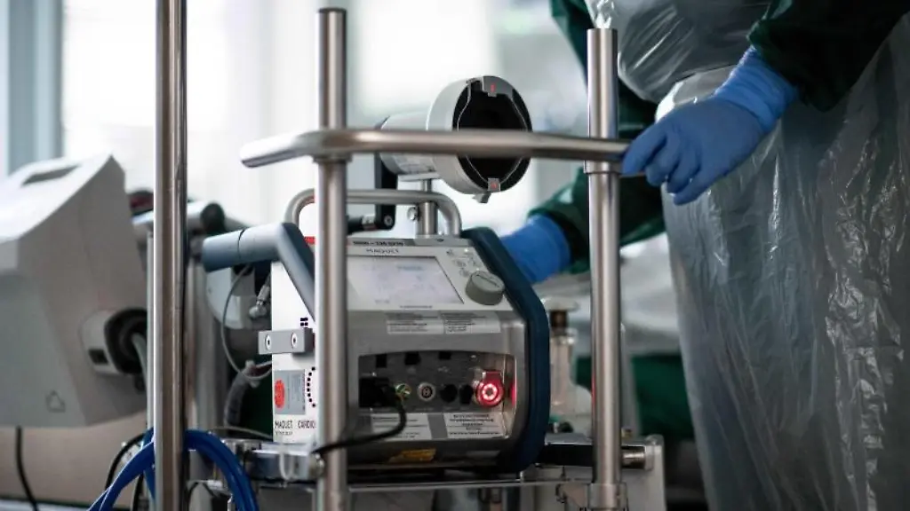 Eine-Pflegekraft-steht-auf-einer-Intensivstation-in-einem-Zimmer-und-bedient-eine-Herz-Lungen-Maschine