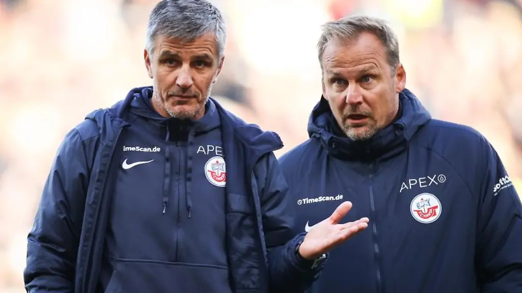 Rostocks-Trainer-Jens-Haertel-l-und-Martin-Pieckenhagen-gehen-nach-dem-Spiel-ueber-Platz