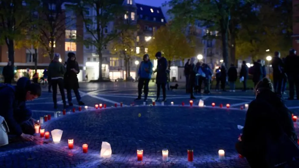 Besucher-des-Joseph-Carlebach-Platz-zuenden-Grablichter-an
