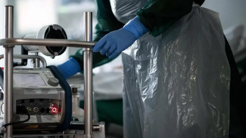 Eine-Mitarbeiterin-der-Pflege-steht-in-einem-Zimmer-einer-Corona-Intensivstation