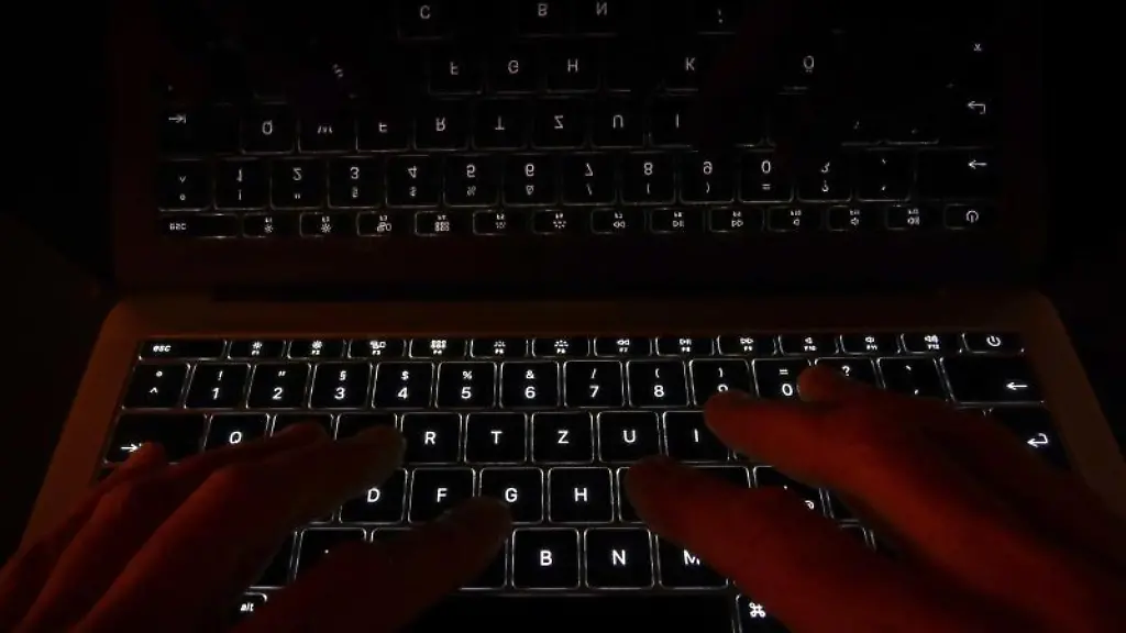 Haende-liegen-auf-der-leuchtenden-Tastatur-eines-Laptops