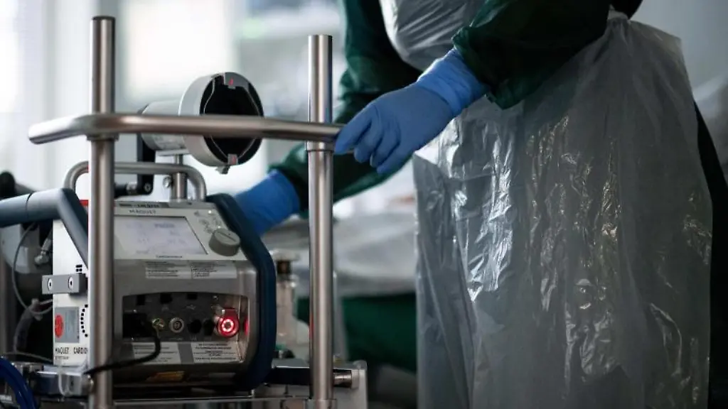 Eine-Mitarbeiterin-der-Pflege-steht-in-einem-Zimmer-einer-Corona-Intensivstation