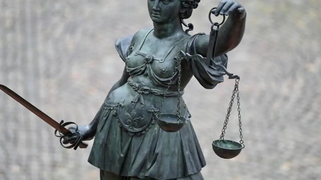 Eine-Statue-der-Justitia-haelt-eine-Waage-und-ein-Schwert-in-der-Hand