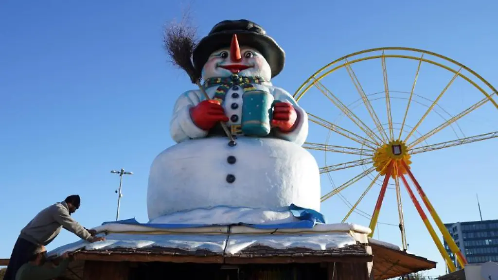 Eine-Bude-mit-einem-Schneemann-auf-dem-Dach-steht-auf-dem-Hamburger-Winterdom