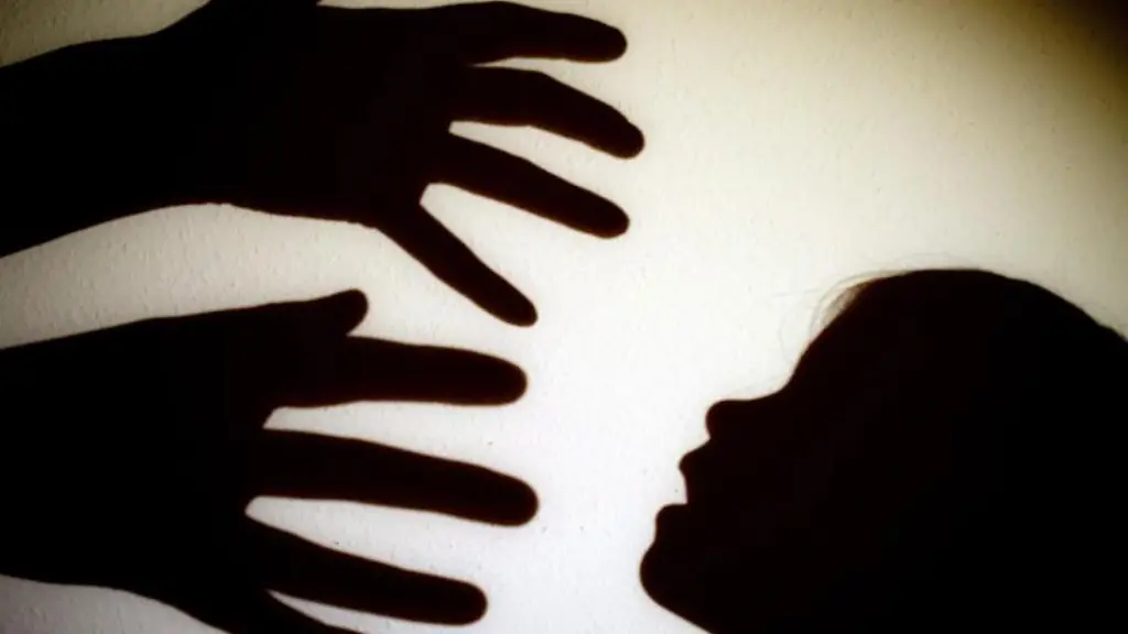 Schatten-von-Haenden-einer-erwachsenen-Person-und-dem-Kopf-eines-Kindes-sind-an-einer-Wand-zu-sehen