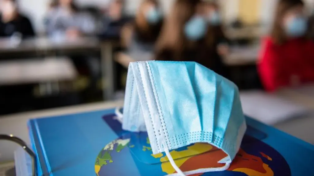 Ein-Mund-und-Nasenschutz-liegt-im-Unterricht-einer-Schulkasse