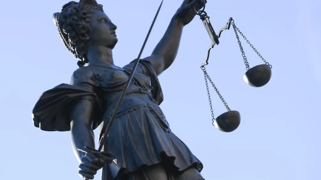 Eine-Statue-der-Justitia-steht-unter-freiem-Himmel