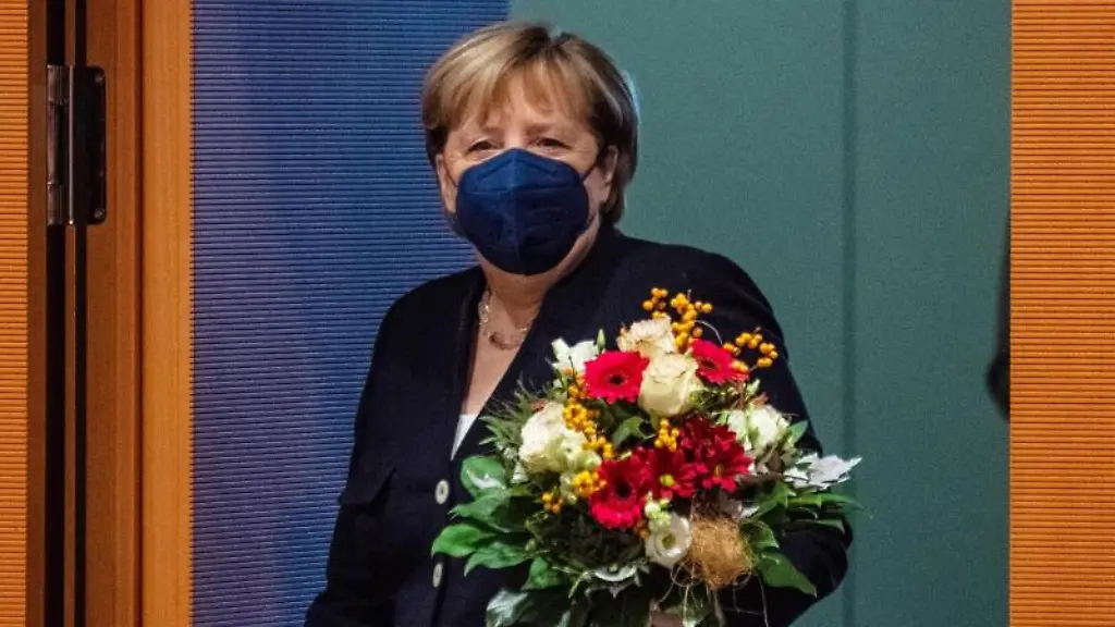 Bundeskanzlerin-Angela-Merkel-CDU-geht-mit-einem-Blumenstrauss-in-der-Hand