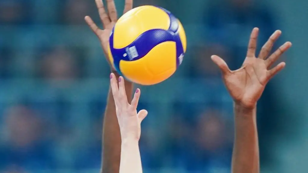 Spielerinnen-strecken-ihre-Arme-in-Richtung-eines-Volleyballs