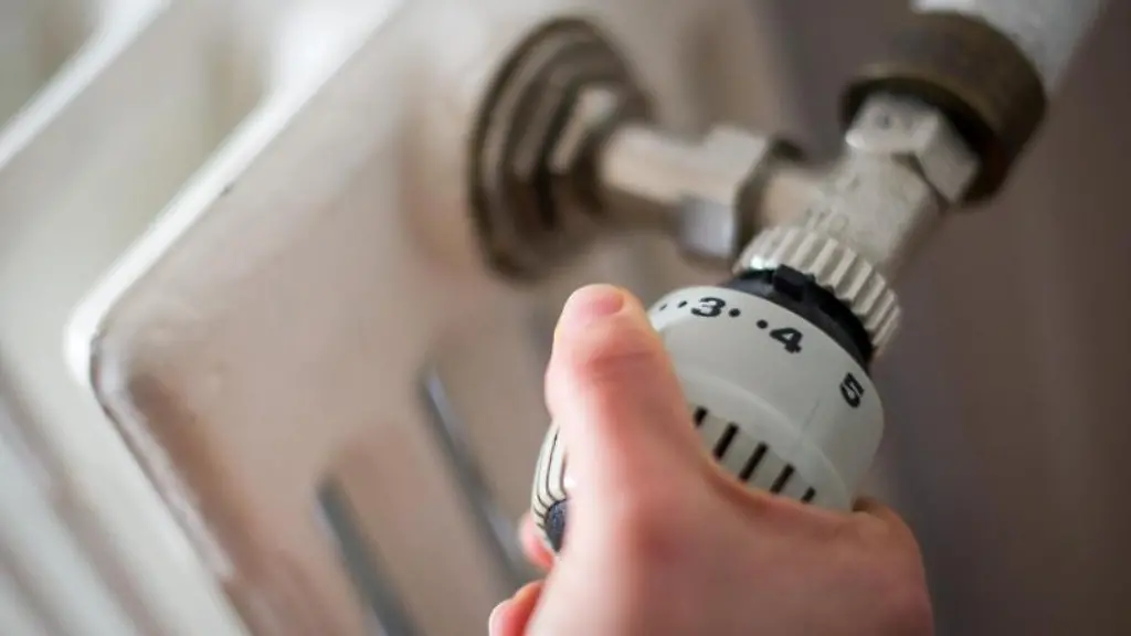 Eine-Frau-dreht-am-Thermostat-einer-Heizung