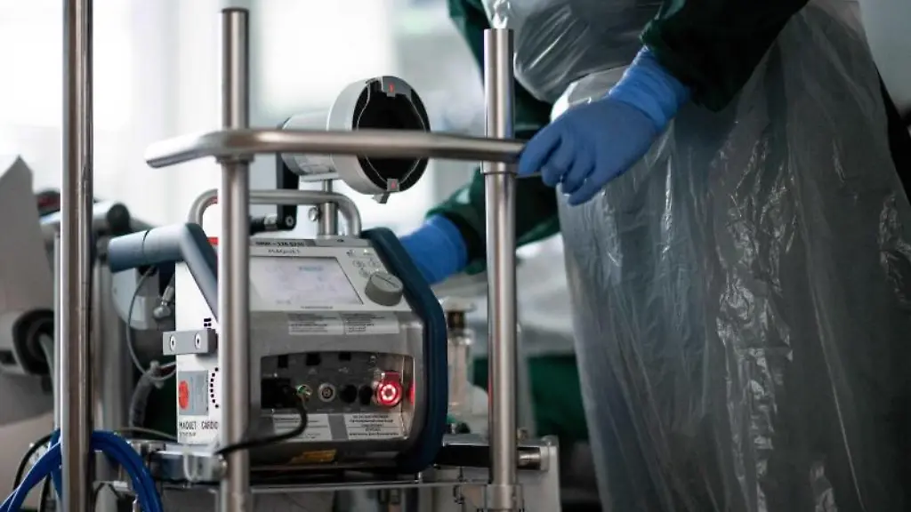 Eine-Pflegekraft-steht-auf-einer-Intensivstation-in-einem-Zimmer-und-bedient-eine-Herz-Lungen-Maschine