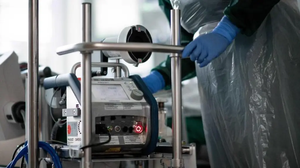 Eine-Pflegekraft-steht-auf-einer-Intensivstation-in-einem-Zimmer-und-bedient-eine-Herz-Lungen-Maschine