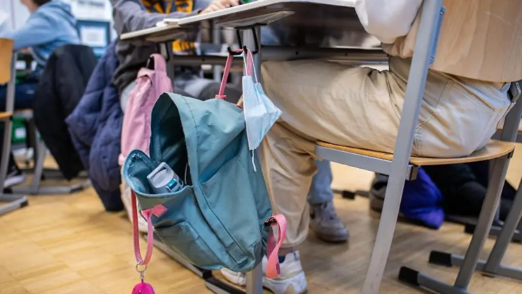 In-der-9-Klasse-einer-Gesamtschule-haengt-an-einem-Klassentisch-neben-einem-Rucksack-eine-Mund-Nasenbedeckung