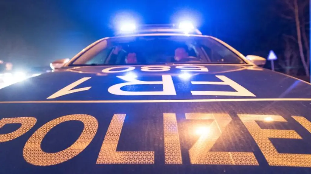 Ein-Polizeifahrzeug-steht-mit-leuchtendem-Blaulicht-auf-der-Strasse