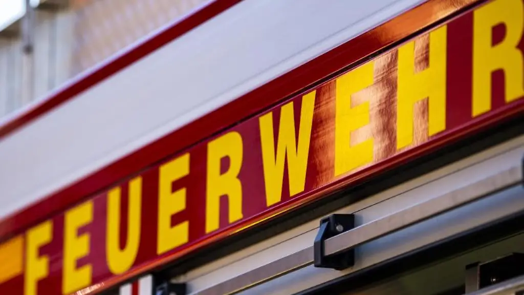 Auf-dem-Einsatzfahrzeug-ist-in-gelber-Farbe-der-Schriftzug-Feuerwehr-zu-lesen