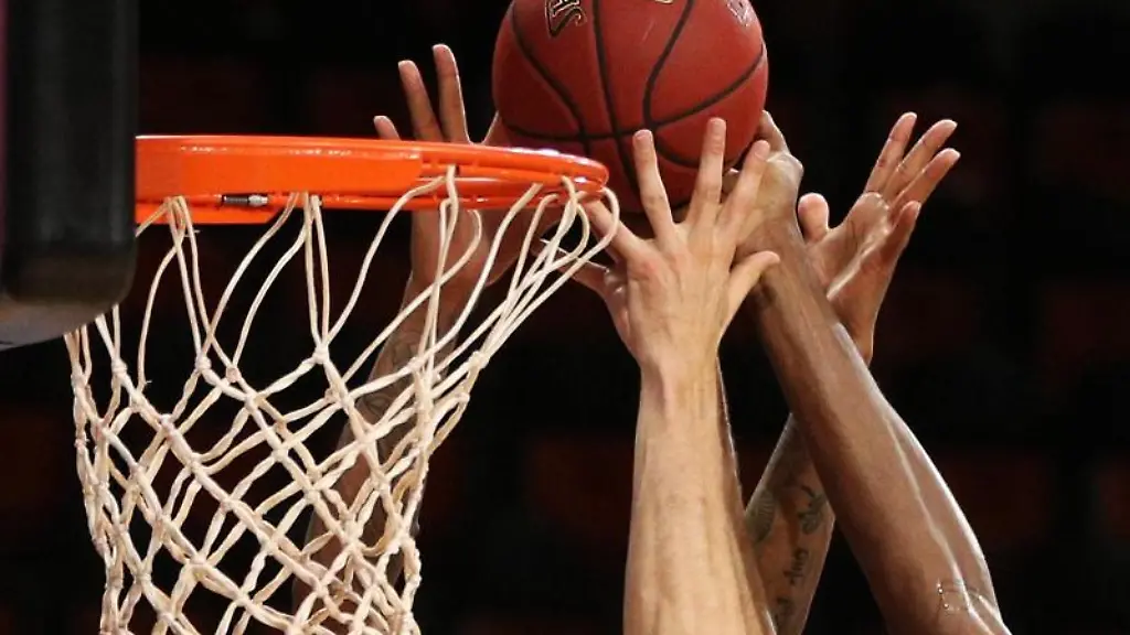 Spieler-zweier-Basketballmannschaften-im-Kampf-um-den-Ball