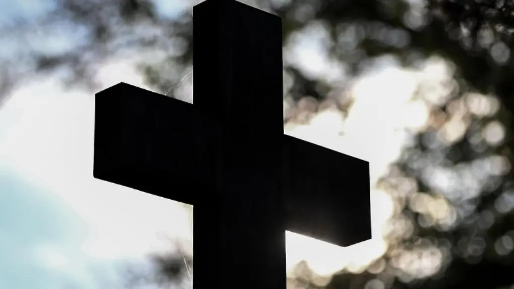 Ein-Kreuz-im-Gegenlicht-auf-einem-Friedhof