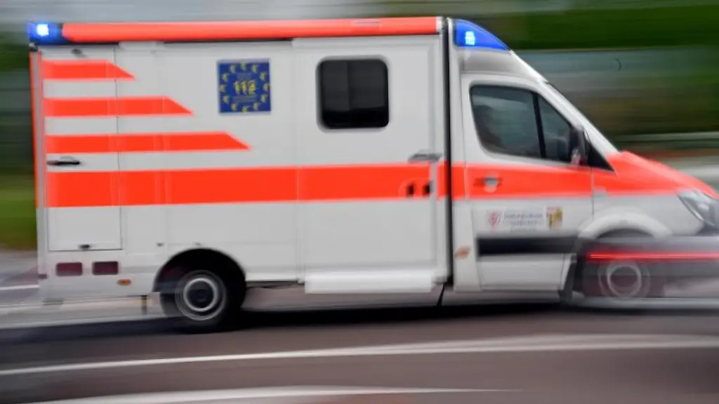 Ein-Krankenwagen-faehrt-mit-Blaulicht-auf-einer-Strasse