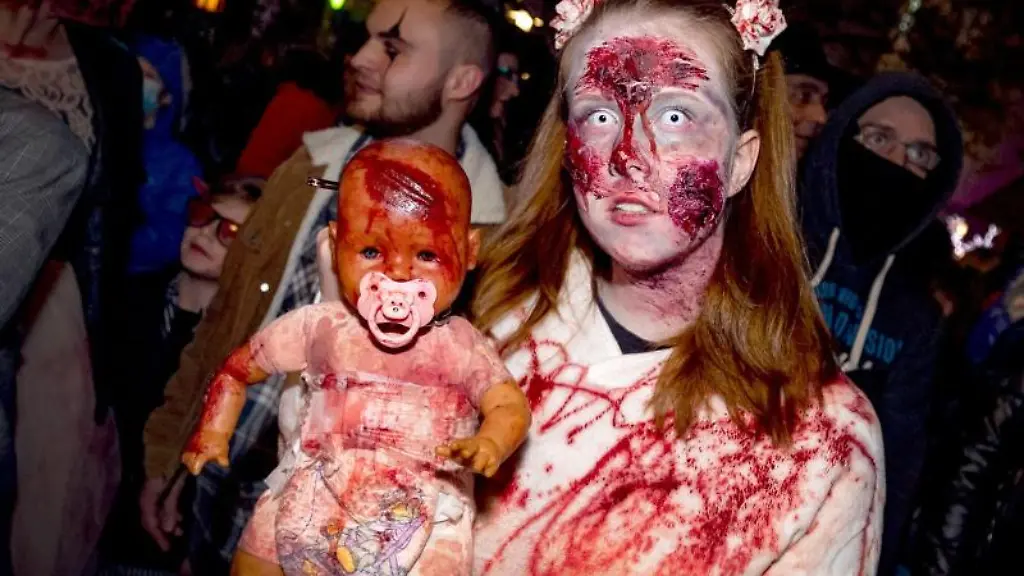 Eine-zu-Halloween-verkleidete-Frau-posiert-mit-einer-Babypuppe