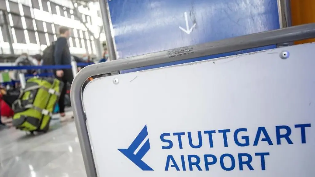 Fluggaeste-gehen-mit-ihrem-Gepaeck-zu-Check-In-Schaltern-am-Flughafen-Stuttgart