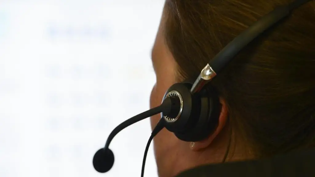 Eine-Frau-mit-einem-Headset-sitzt-an-einem-Arbeitsplatz