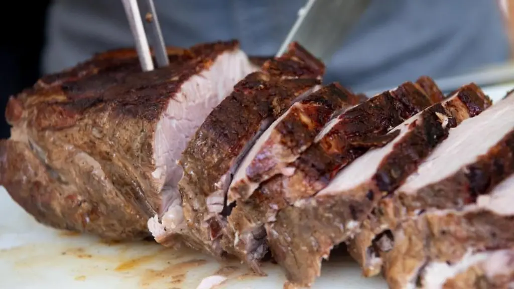 Ein-Koch-schneidet-gegrilltes-Schweinefleisch-auf-einem-Brett