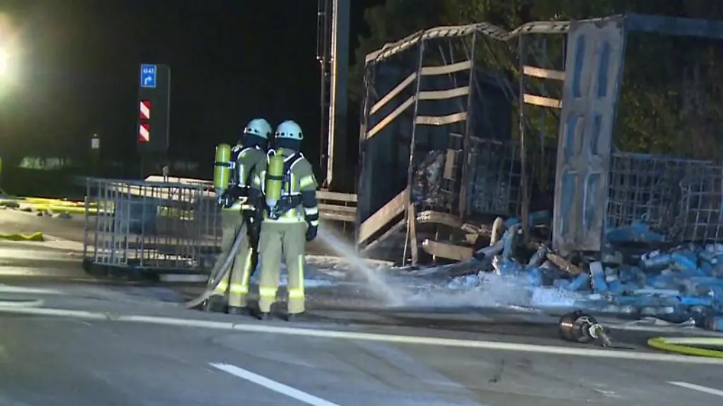 Feuerwehrleute-loeschen-die-Ladung-eines-Gefahrguttransporters-auf-der-Autobahn